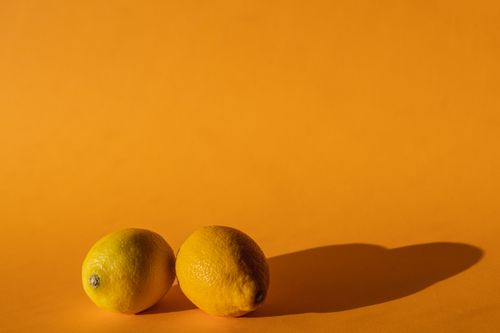 Free Ripe vivid lemons composed on yellow background of modern studio in bright daylight Stock Photo
