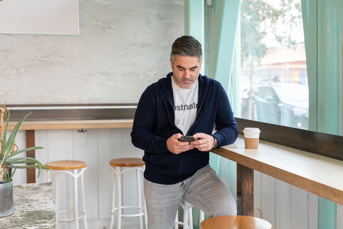 A Man in the Coffee Shop Using a Mobile Phone