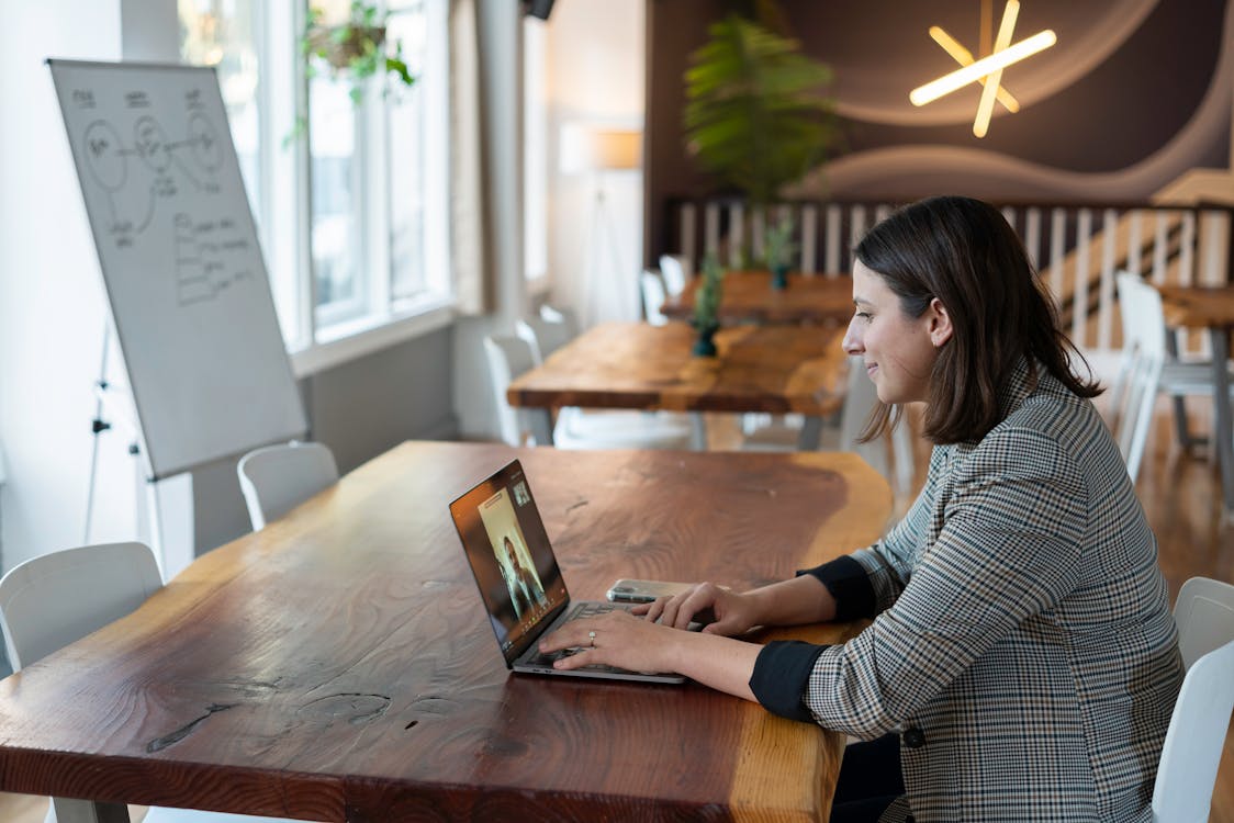 A Woman in Plaid Long Sleeves Using a Laptop