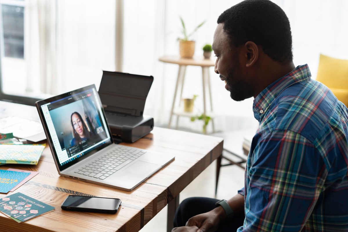 Man in blue plaid long sleeves using a laptop