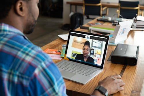 A Man in Blue Plaid Long Sleeves Using a Laptop