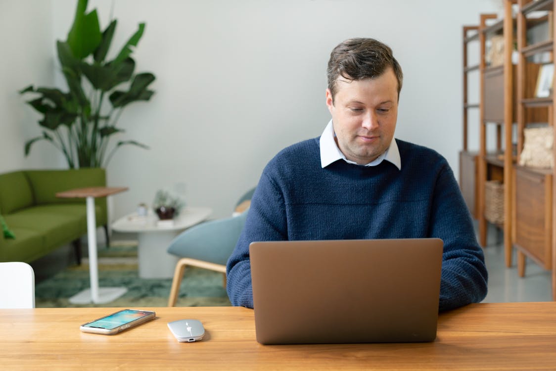 A Man Using a Laptop Indoors
