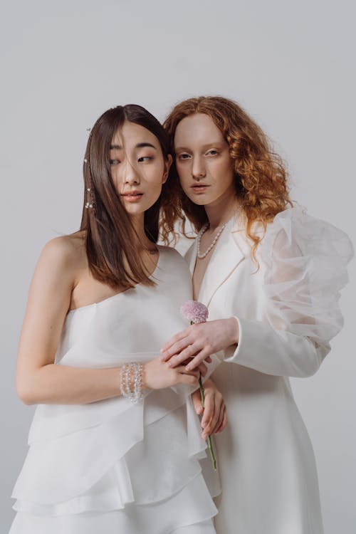 Women in Elegant Dresses on White Studio Background