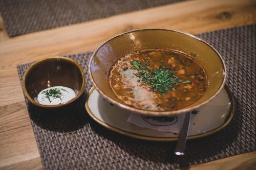 Коричневая керамическая миска с коричневым супом