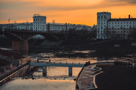Stunning sunset view of the Daugava River and iconic buildings in Viciebsk, Belarus, showcasing urban architecture and natural beauty.