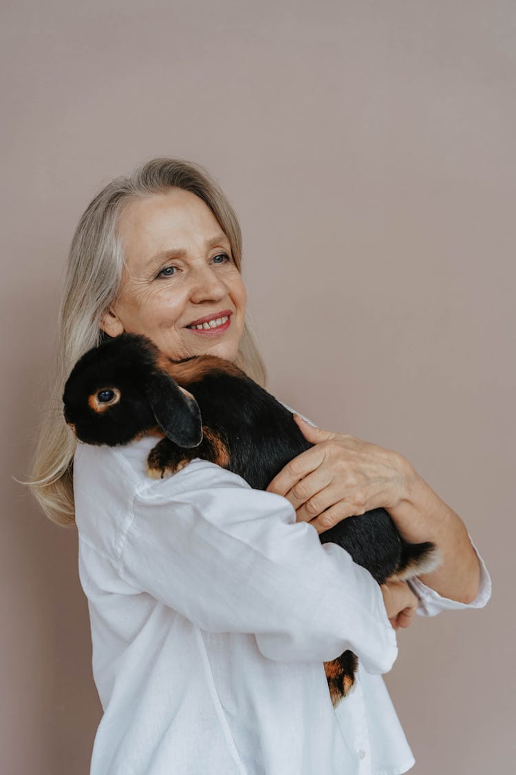 A Woman Petting A Black Rabbit