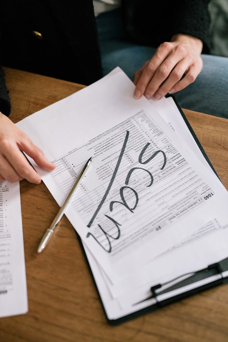 A Person Holding A Scam Document 