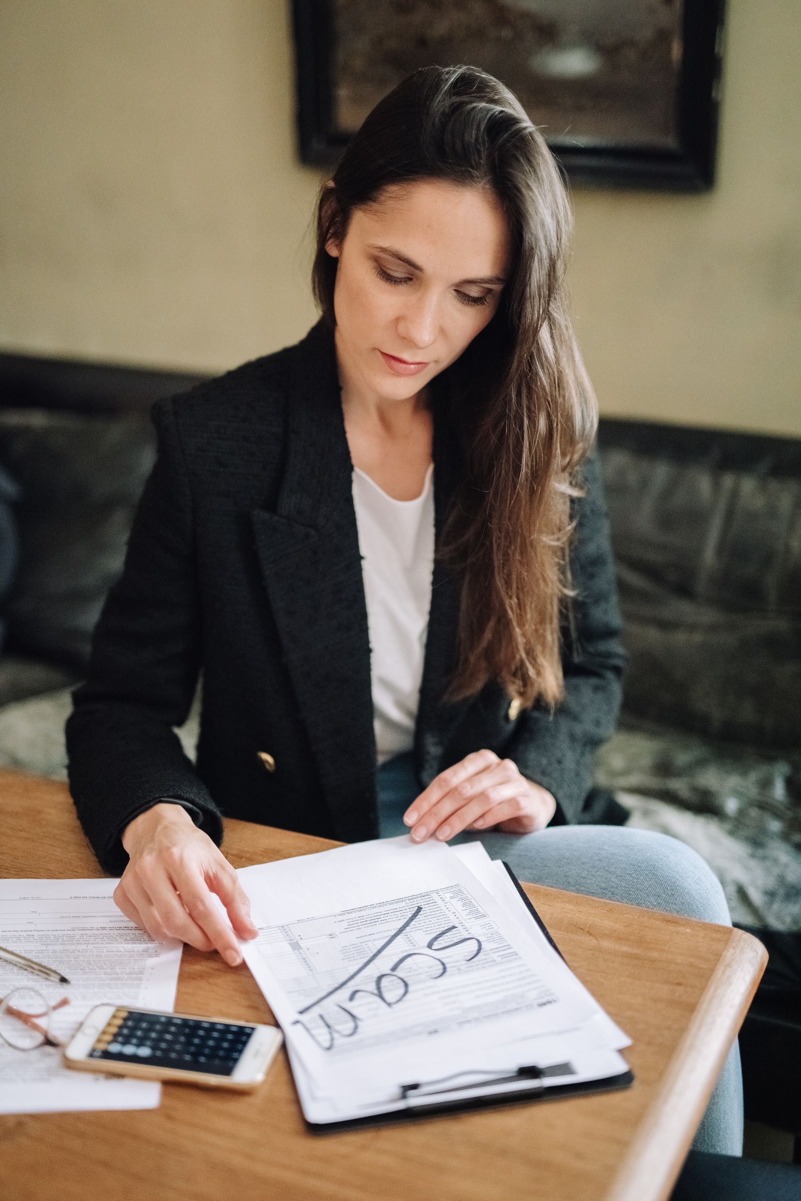 A woman reviewing documents at her desk