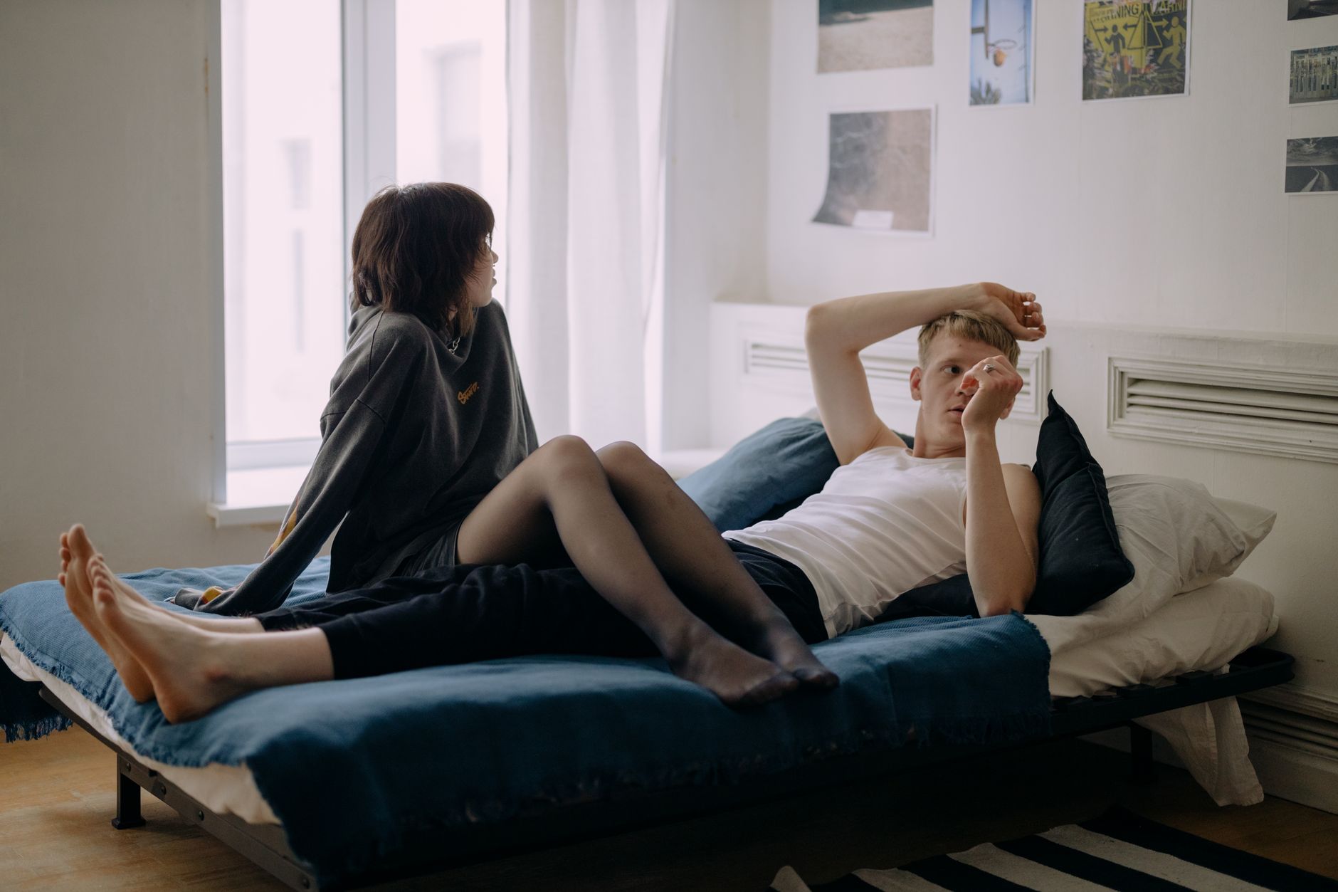 Young couple relaxing together in a modern, stylish bedroom setting.