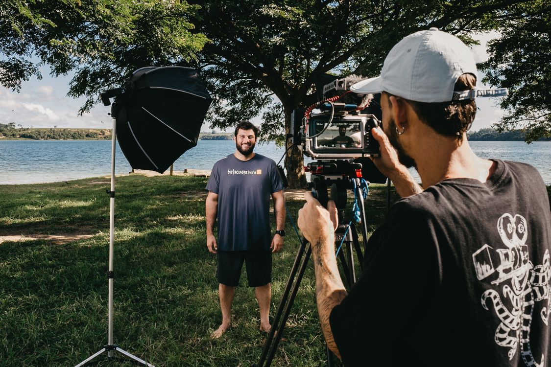 Cameraman shooting interview of man on coast · Free Stock Photo