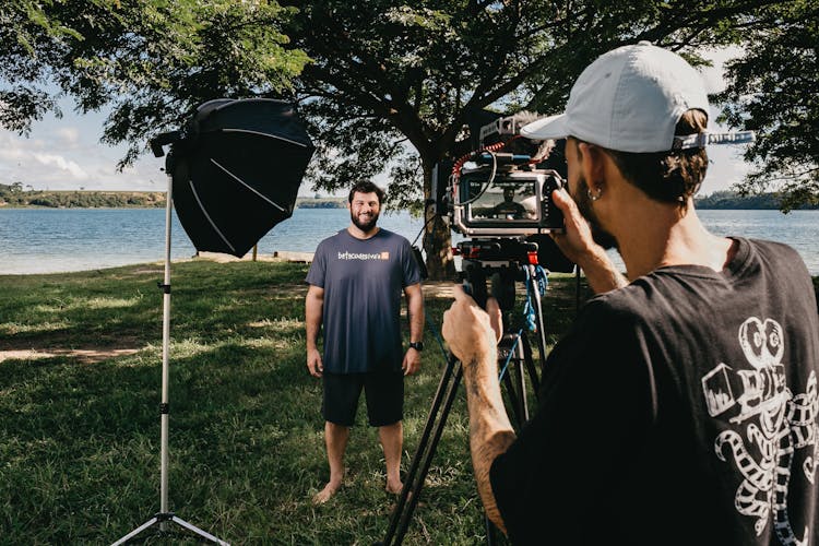 Cameraman Shooting Interview Of Man On Coast