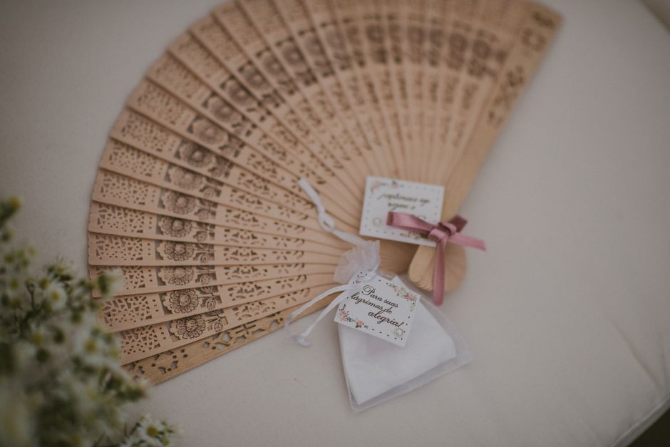 wedding cufflinks engraved - Close-up of a decorative wooden hand fan and wedding gifts on a table.