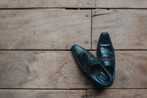 Free Black Leather Shoes on a Wooden Floor Stock Photo