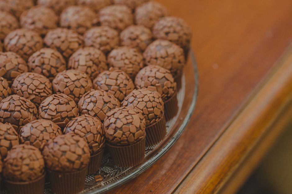 Delicious round chocolate truffles topped with pieces on a glass plate.