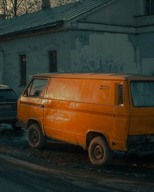 Free A classic yellow van parked in an urban street, evoking nostalgia and vintage charm. Stock Photo