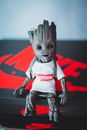 Contemporary creative toy in stylish white t shirt and backpack placed on black cardboard box with inscription in light room