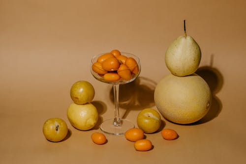 A Bunch of Kumquats in Martini Glass Between Assorted Fruits 