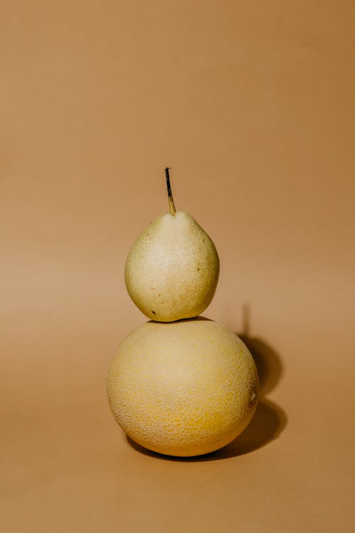 A Still Life Photography of a Pear Fruit on a Melon