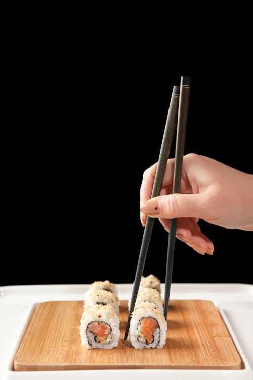 A Person Holding Black Chopsticks 