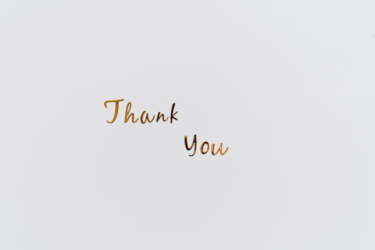 Gold Thank You Text On A White Surface