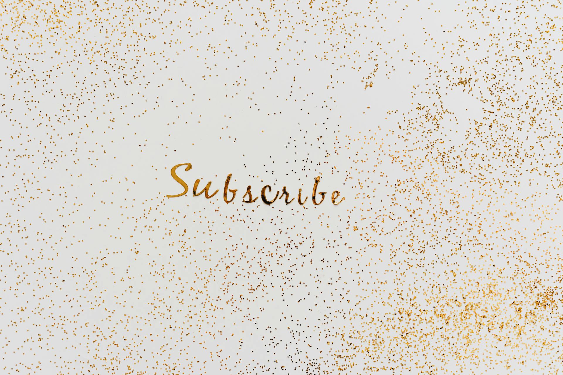 A Word Subscribe in Gold Color Decorated with Scattered Glitters