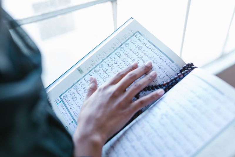 Hands holding the Holy Quran — The 6 Kalimas