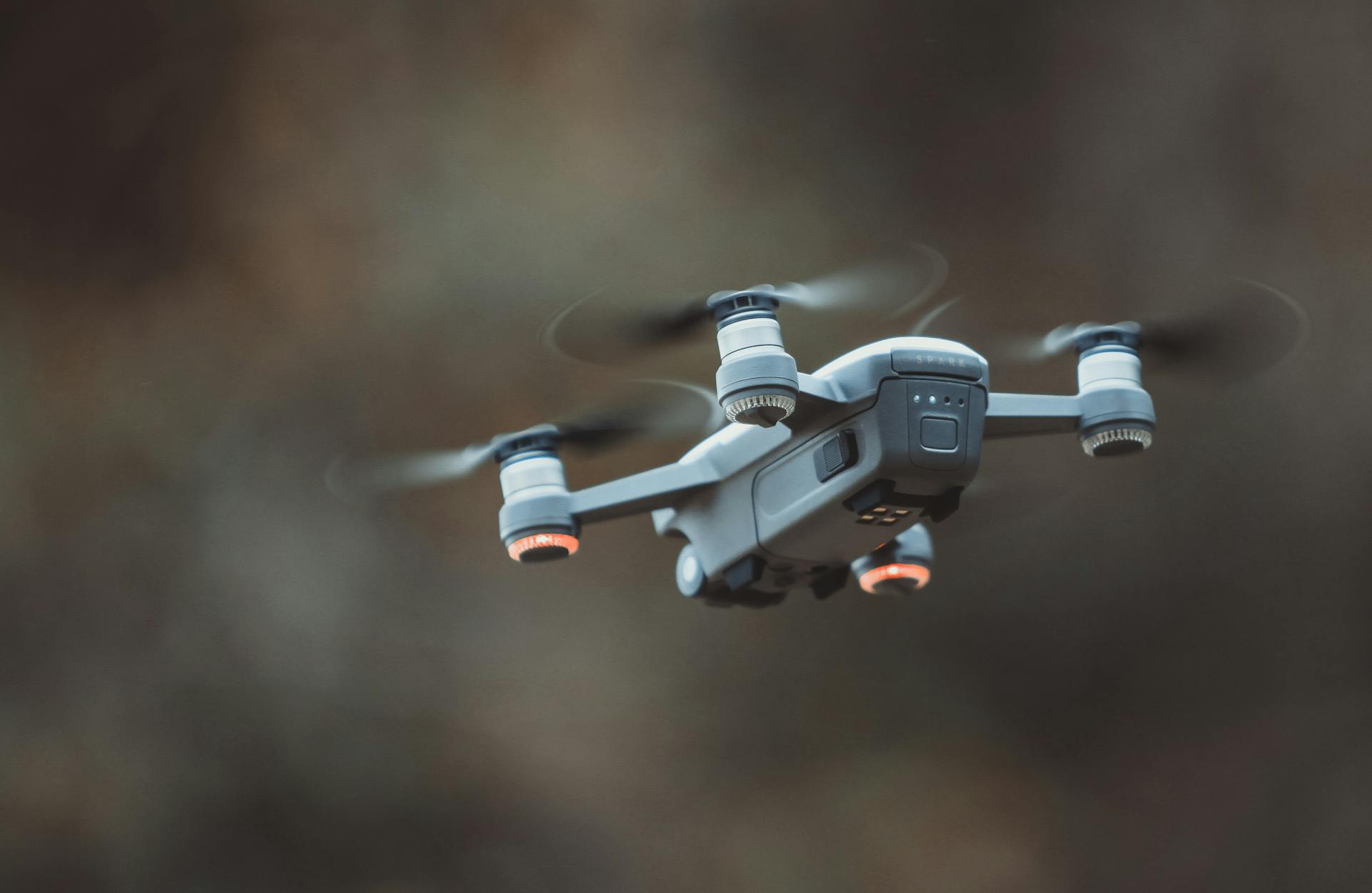 A detailed close-up of a drone flying in an outdoor setting, showcasing its design and technology.