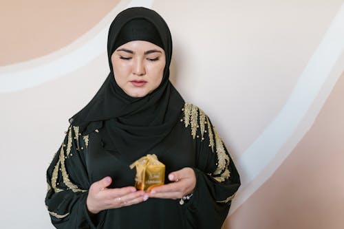 Free A Woman in Black Hijab Holding a Present Stock Photo