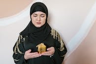 Woman in Black Hijab Holding Yellow Plastic Pack