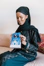 戴头巾的年轻女子在室内欣赏开斋节礼物