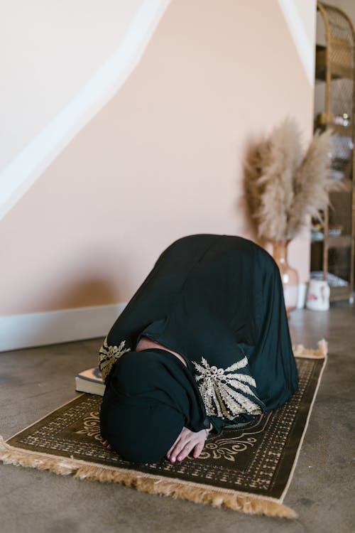 Free Photo of a Woman Praying on a Prayer Rug Stock Photo