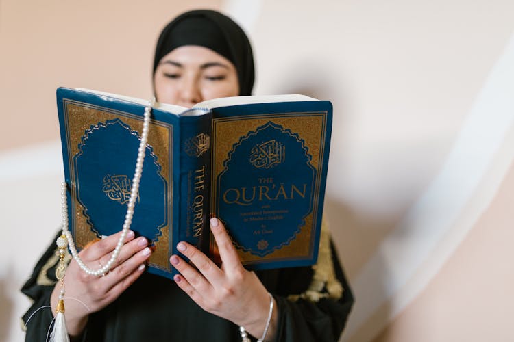 A Woman Reading A Koran