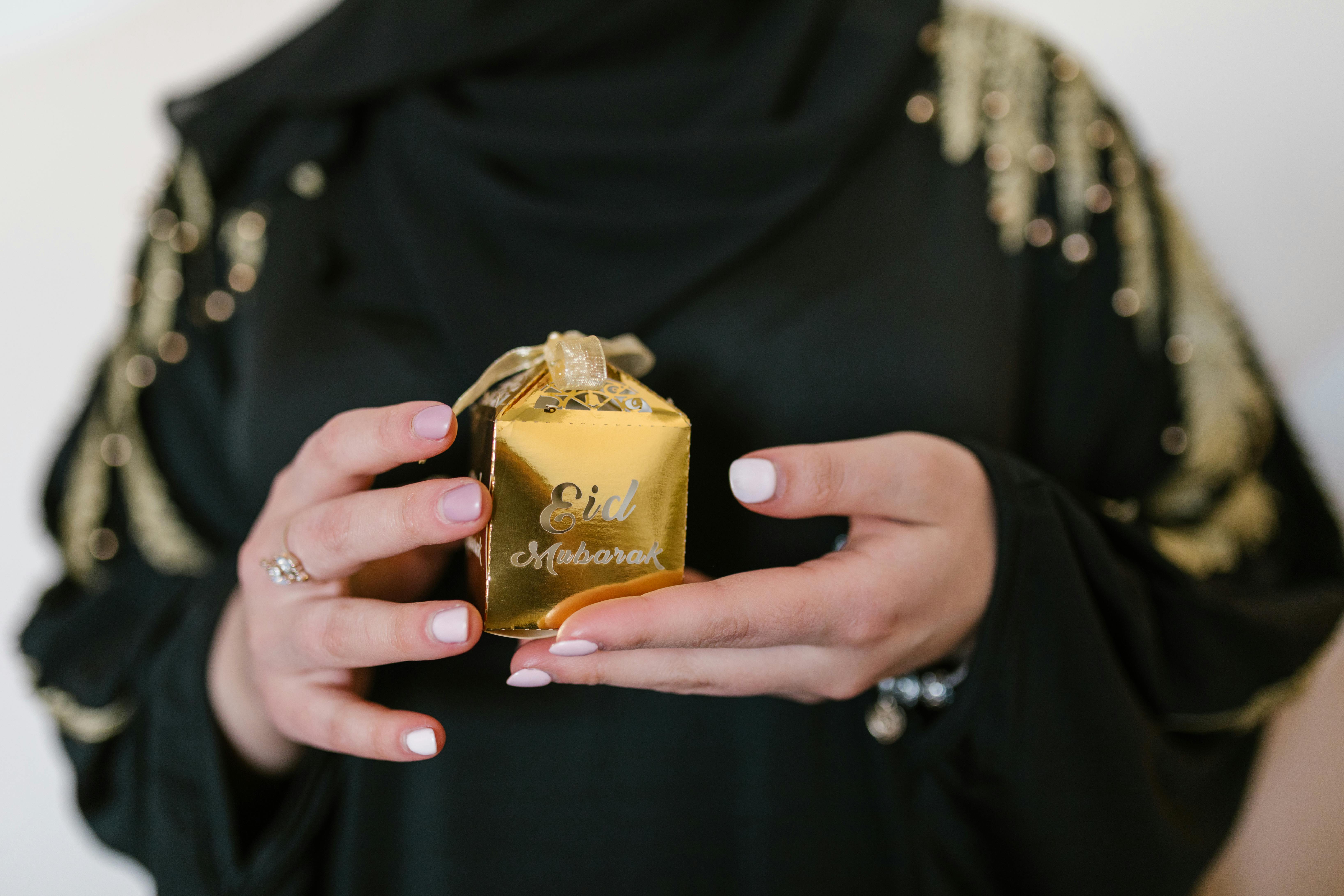 a woman holding a gold box of gift