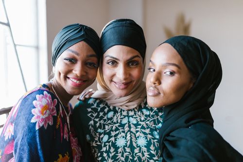 Free Three women wearing hijabs smile warmly in an indoor setting, symbolizing friendship and cultural diversity. Stock Photo