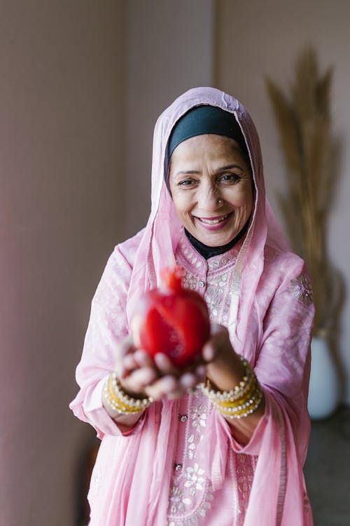 Free A Woman in Pink Hijab Holding Red Candle Stock Photo