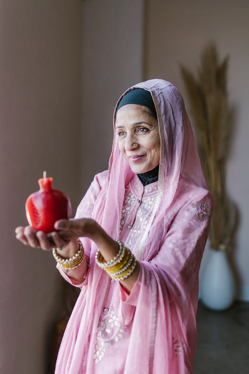 Woman with a Pink Hijab Holding a Red Candle 