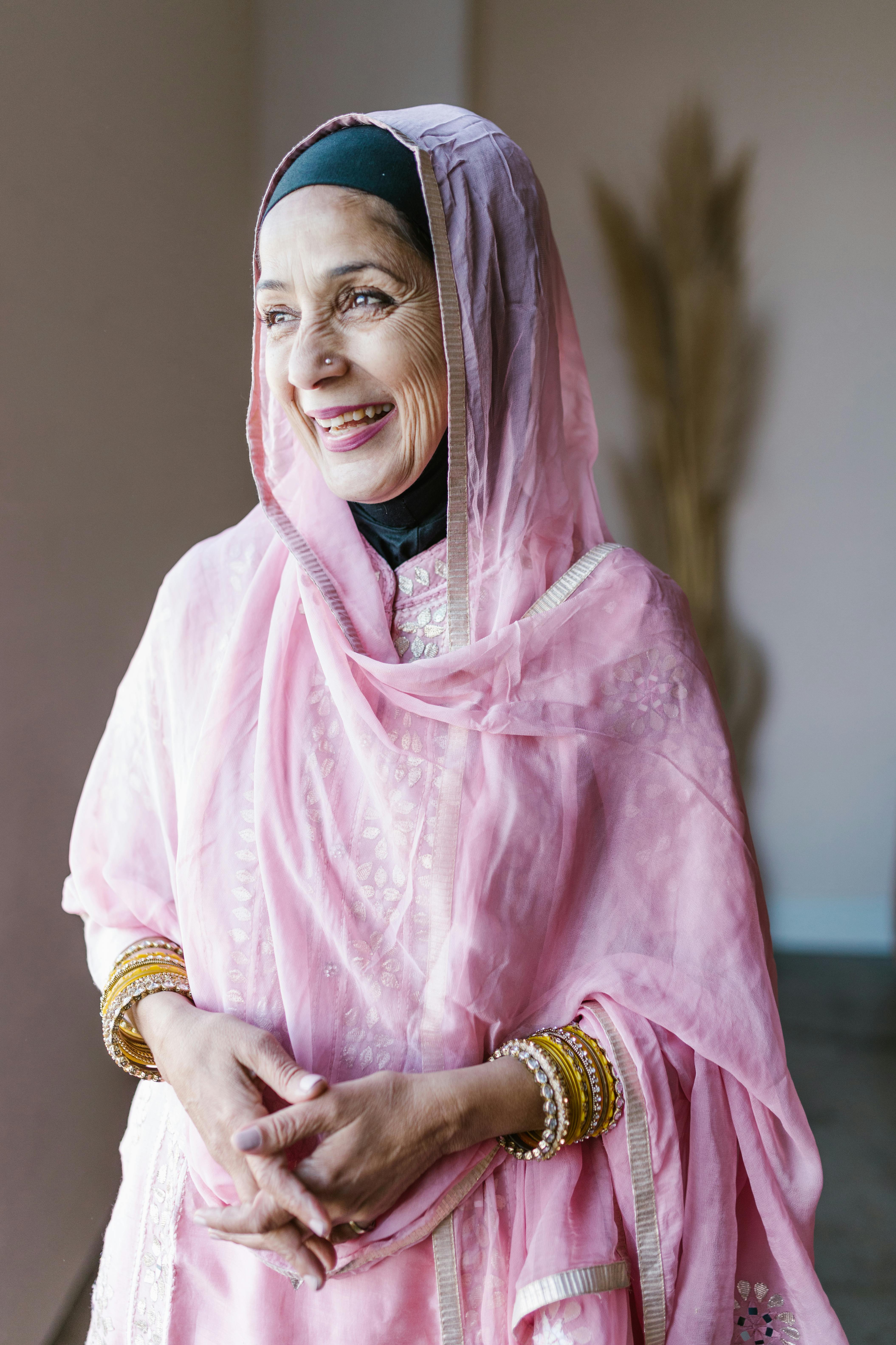 woman in pink hijab and gold bracelet