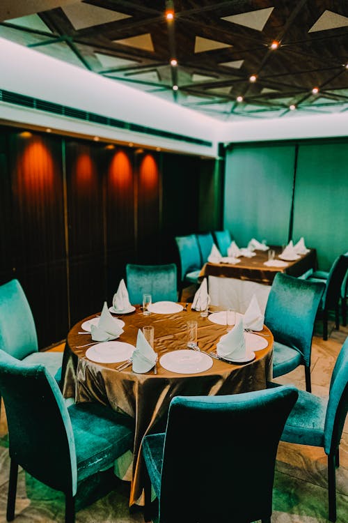 Free A Brown Table with Green Velvety Chairs in a Restaurant
 Stock Photo
