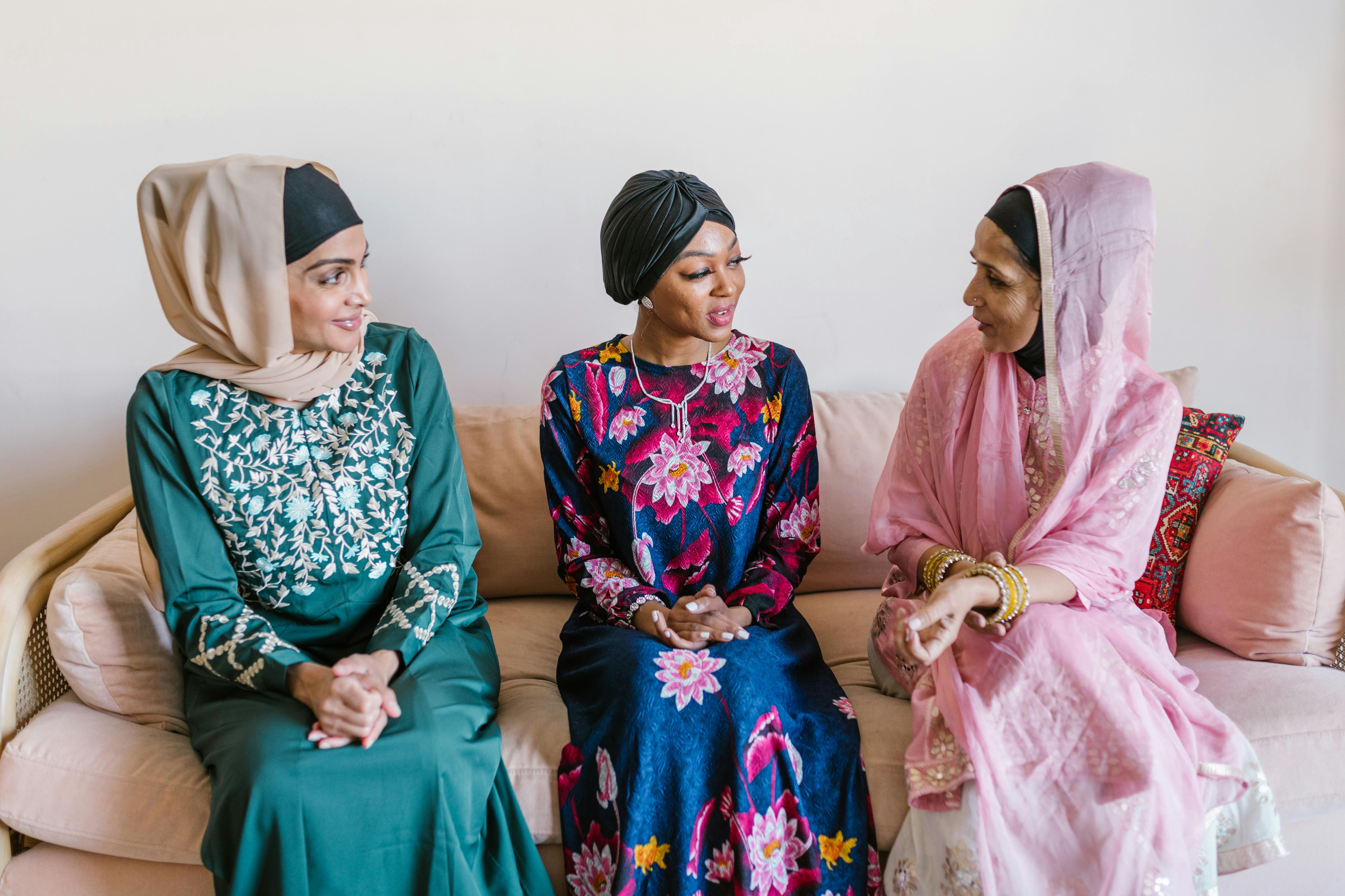 3 women wearing hijab sitting on floor