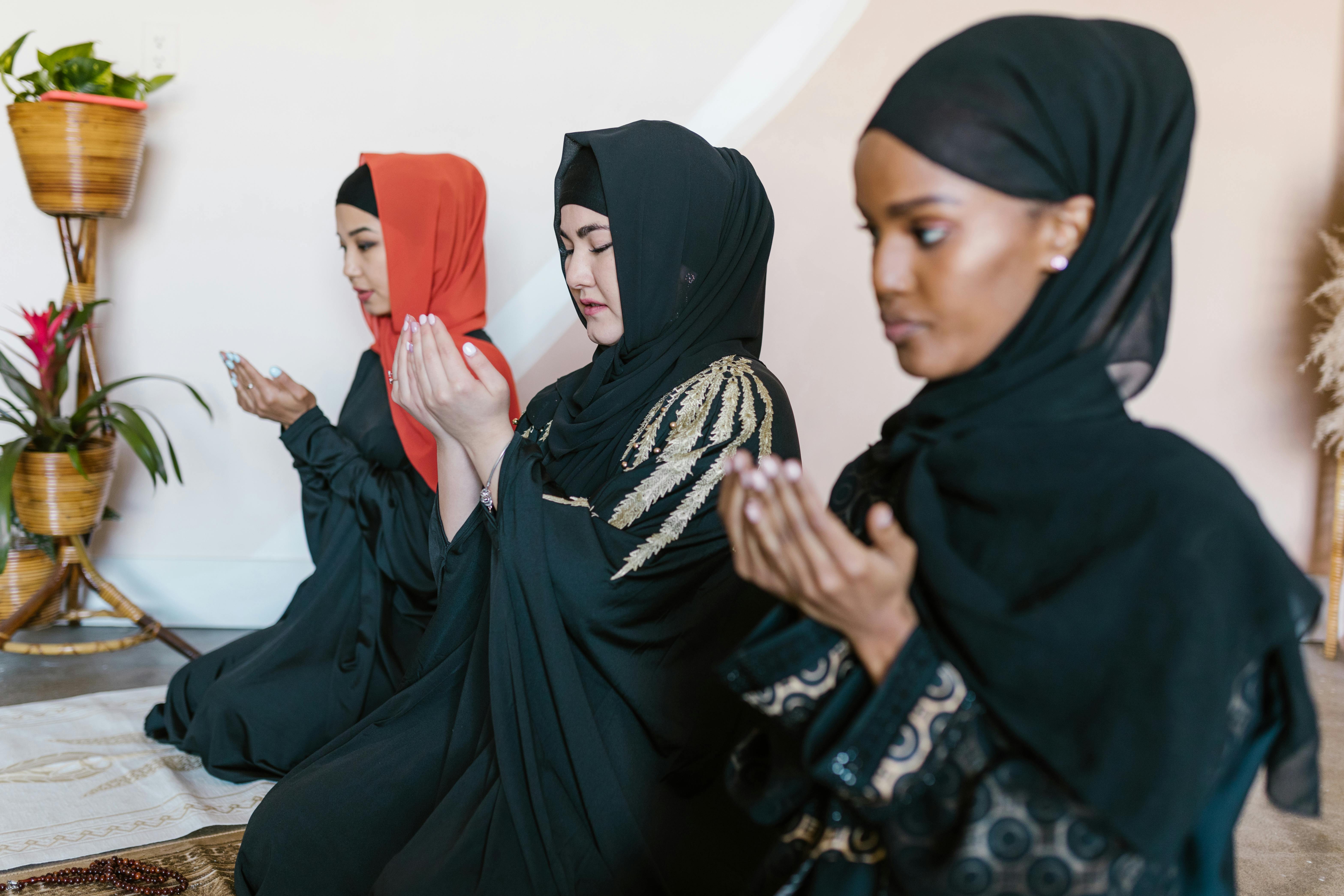 woman in black hijab sitting beside woman in black hijab