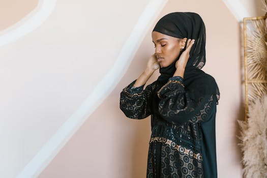 Elegant woman wearing a traditional hijab standing gracefully indoors, embodying modest fashion.