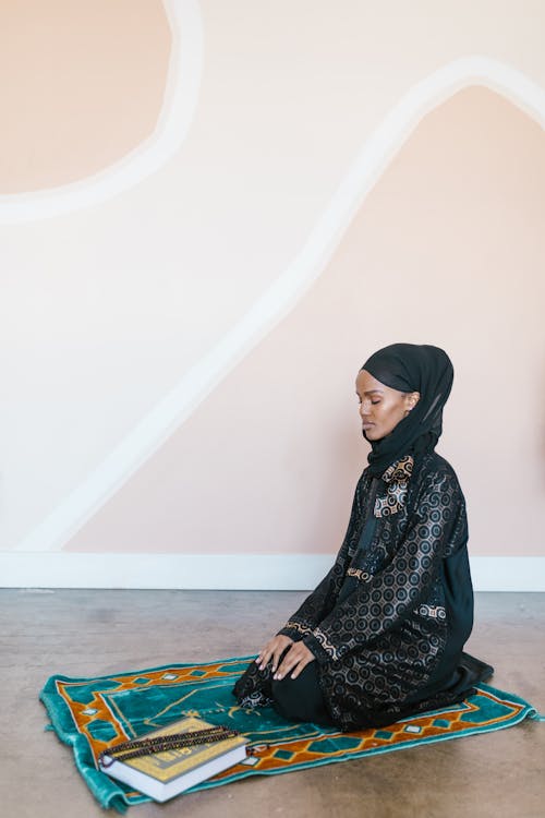 A Woman in Black Printed Traditional Clothing Praying