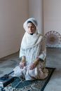 Woman Kneeling on Floor with Eyes Closed