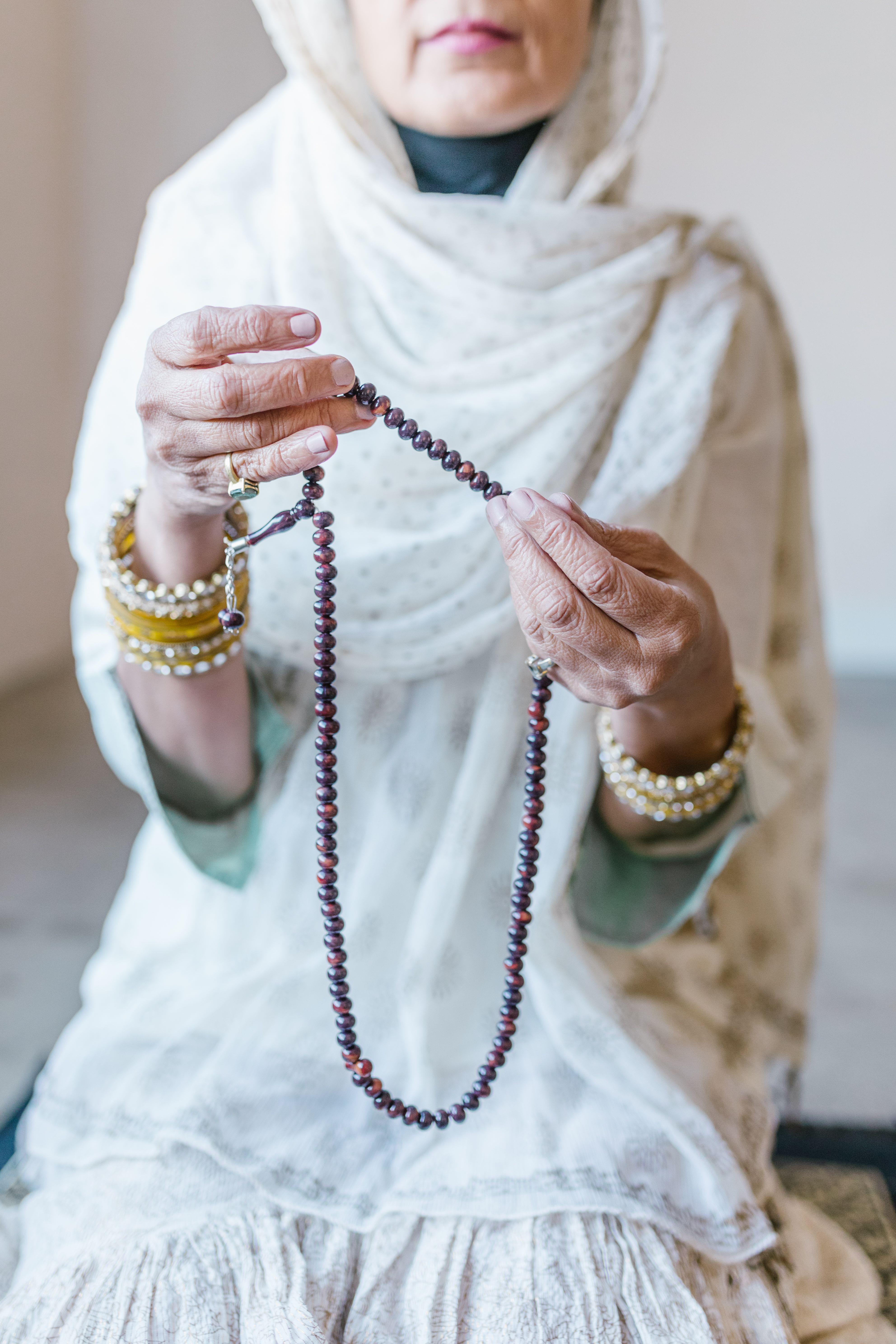 Hands of a Woman Holding a Brown Prayer Beads · Free Stock Photo