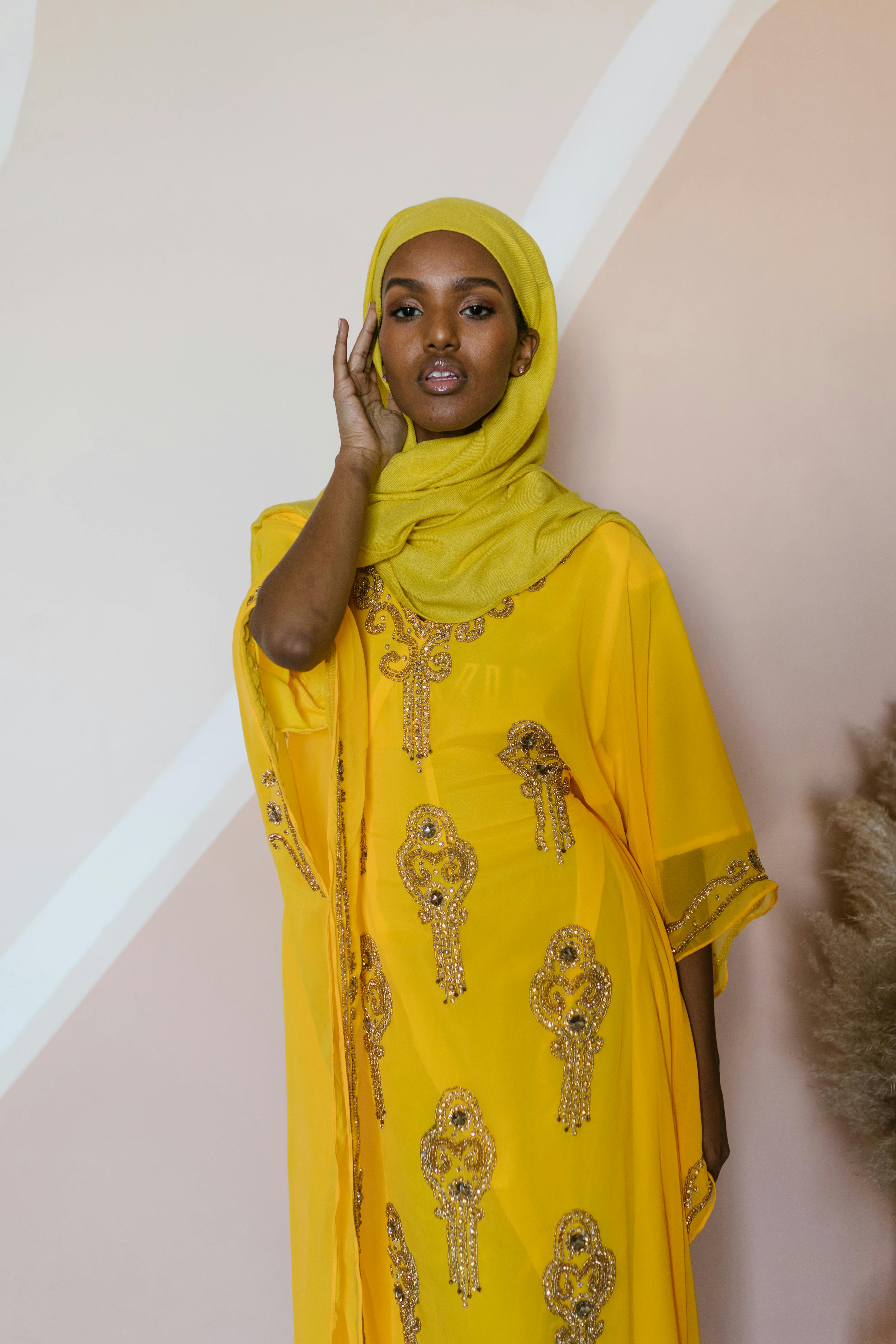 woman in yellow hijab covering her face with yellow hijab