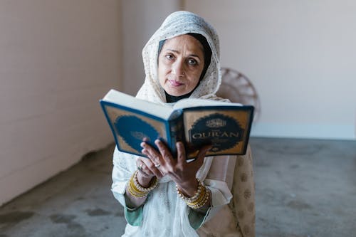 Free Woman in White Hijab Holding Blue Book Stock Photo