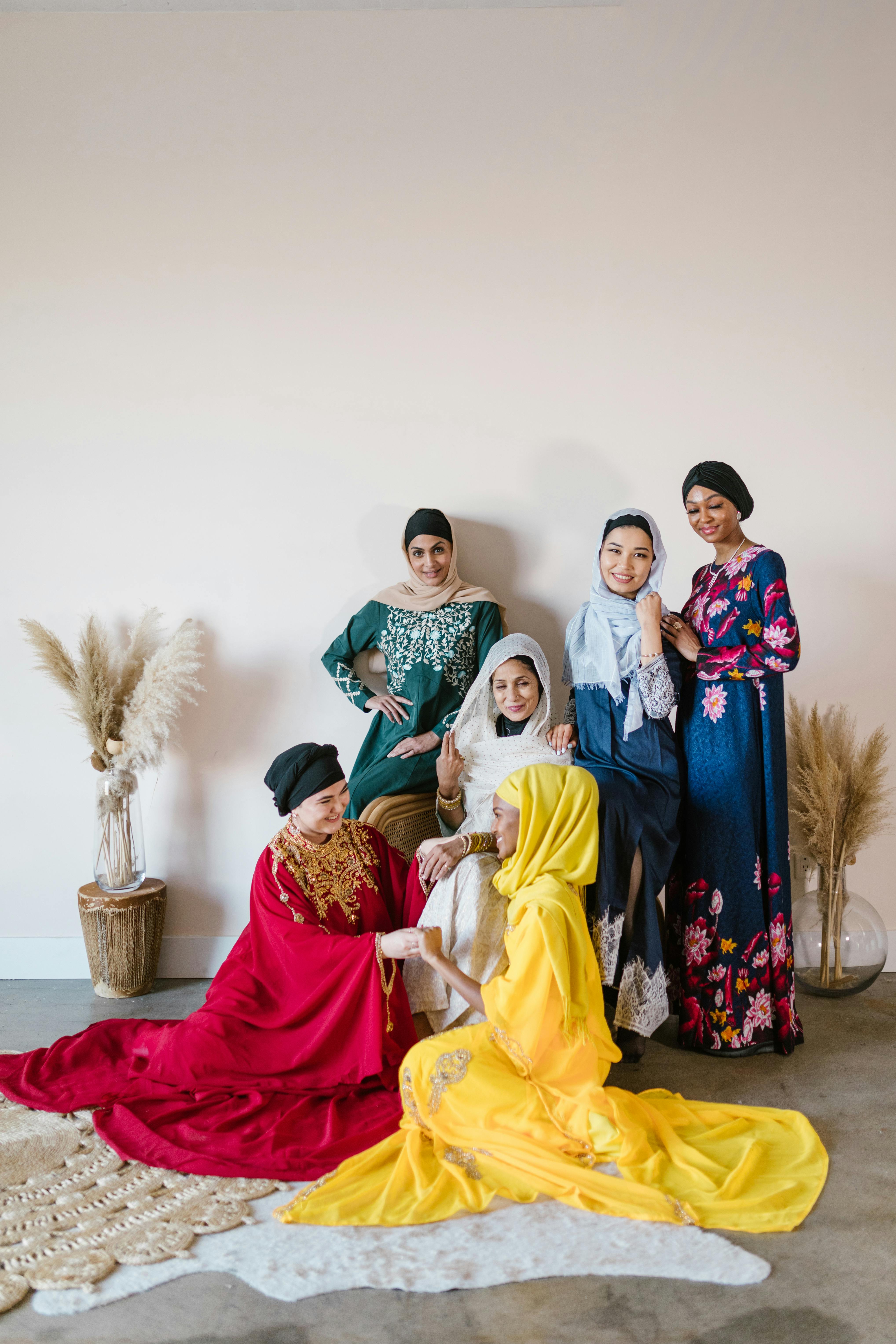 group of women wearing hijab sitting on red sofa