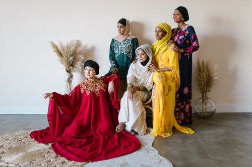 Free A diverse group of women in colorful traditional dresses posing indoors, showcasing cultural richness. Stock Photo