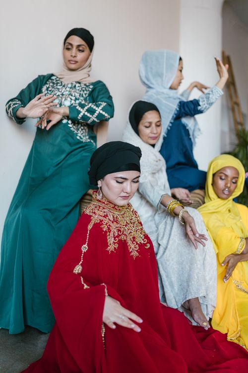 Free A group of women in vibrant traditional dresses, showcasing cultural unity and elegance indoors. Stock Photo