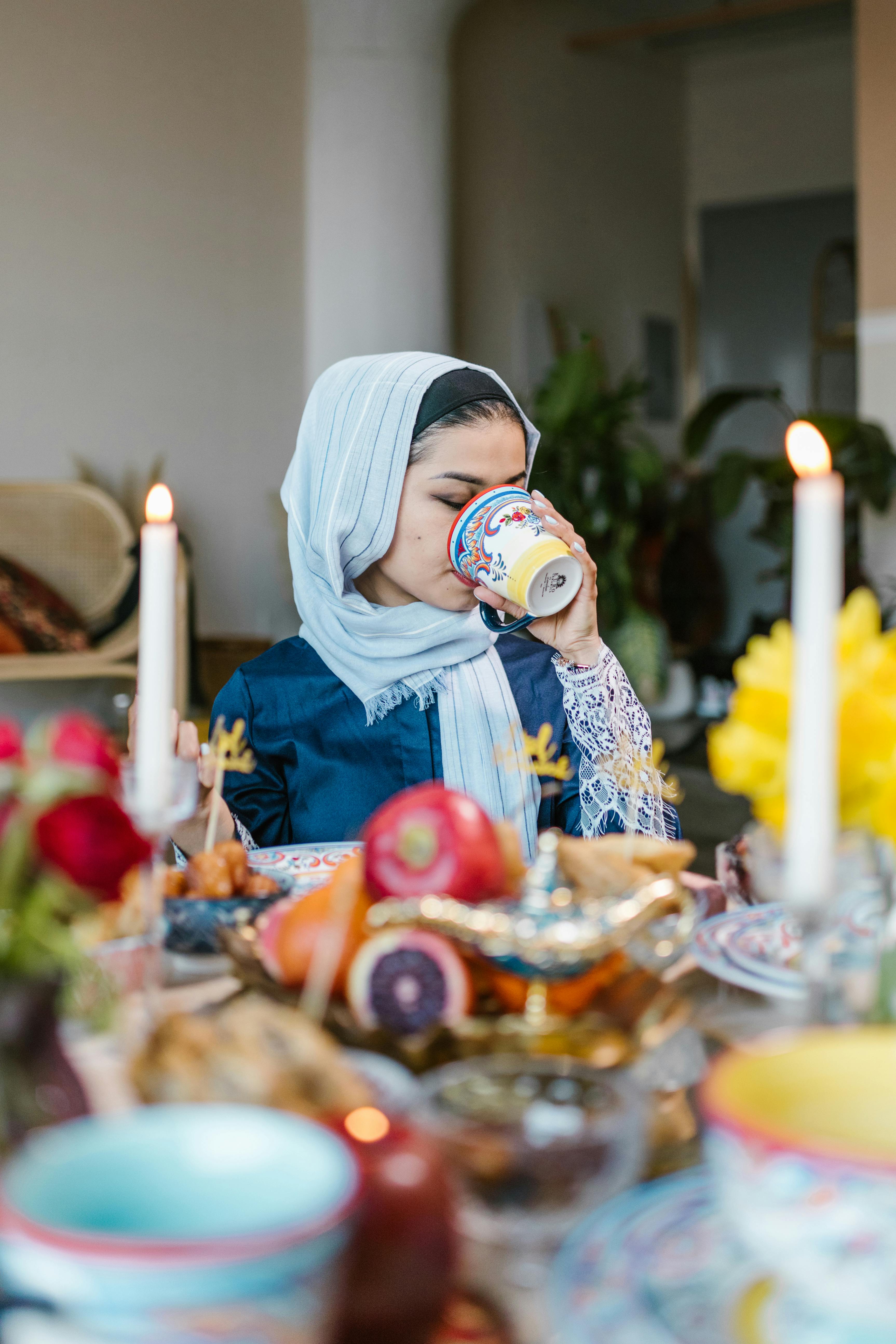 Free Woman in Blue Long Sleeves Drinking From a Ceramic Cup Stock Photo
